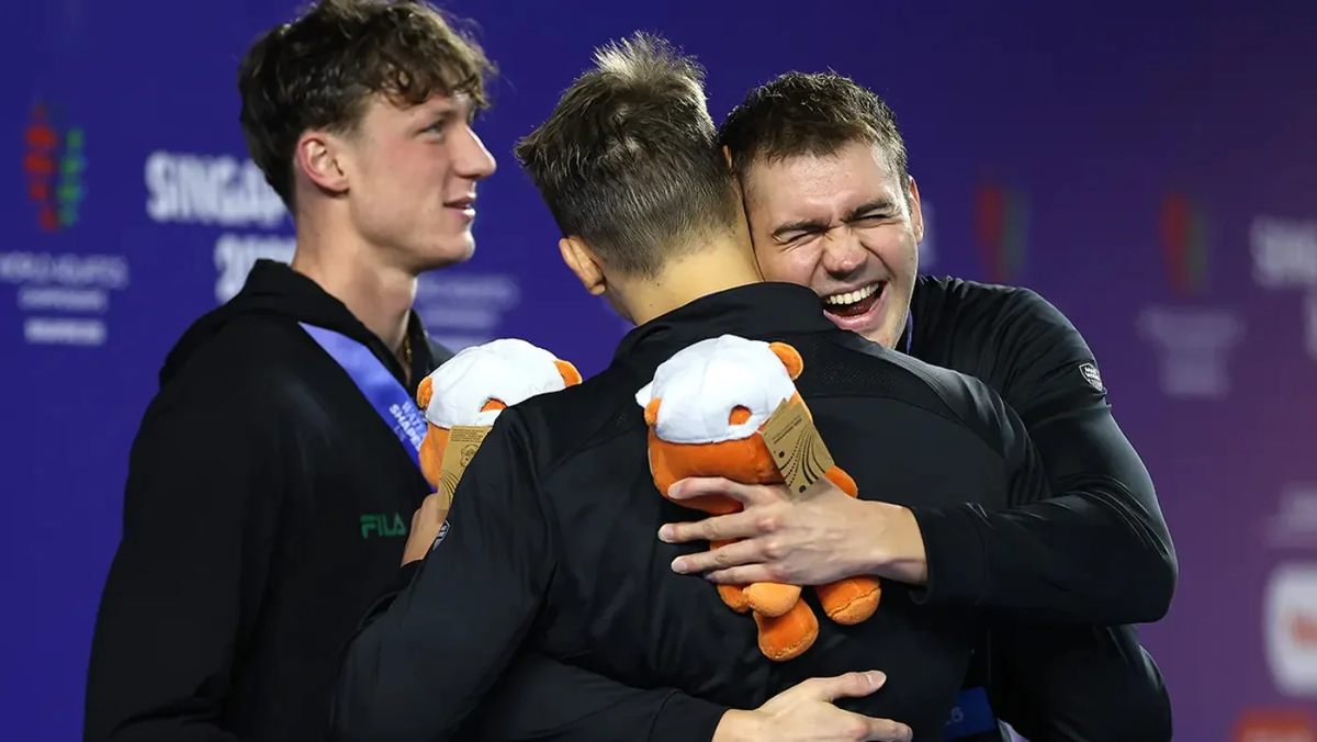 Климент Колесников празднует на пьедестале вместе с остальными призёрами (Фото Hollie Adams / Reuters)