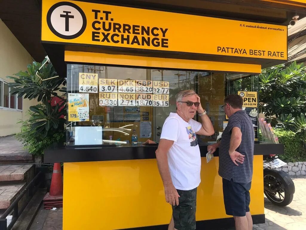 На фото: турист у уличного обменника и банкомата в Таиланде. Лучше всегда иметь при себе немного наличных бат.