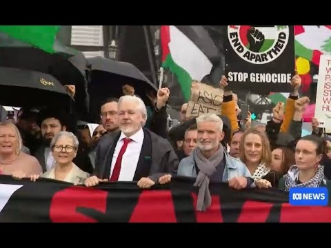 Ассанж во главе марширующих пересекает мост.
Фотография: Мэтью Эбботт/The Guardian. 
