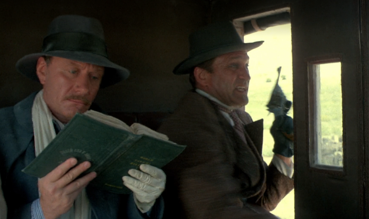 Кадр из фильма «Человек с бульвара Капуцинов». Мистер Фёст (Андрей Миронов) спокойно читает во время перестрелки