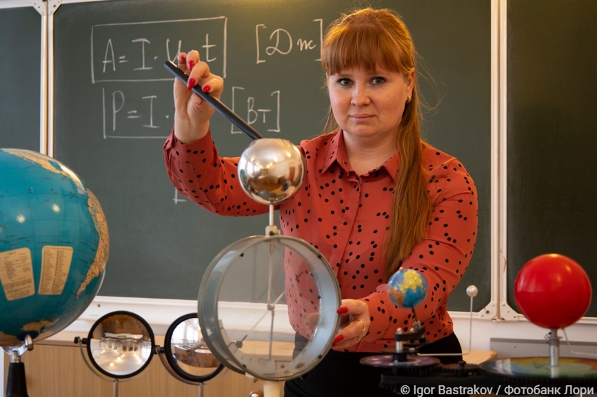 Учительница физики проводит эксперимент с электрометром