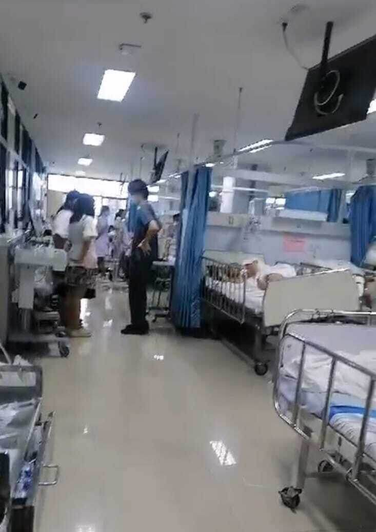 За спиной  мужчины в темно серой униформе  - Настина  койка. 