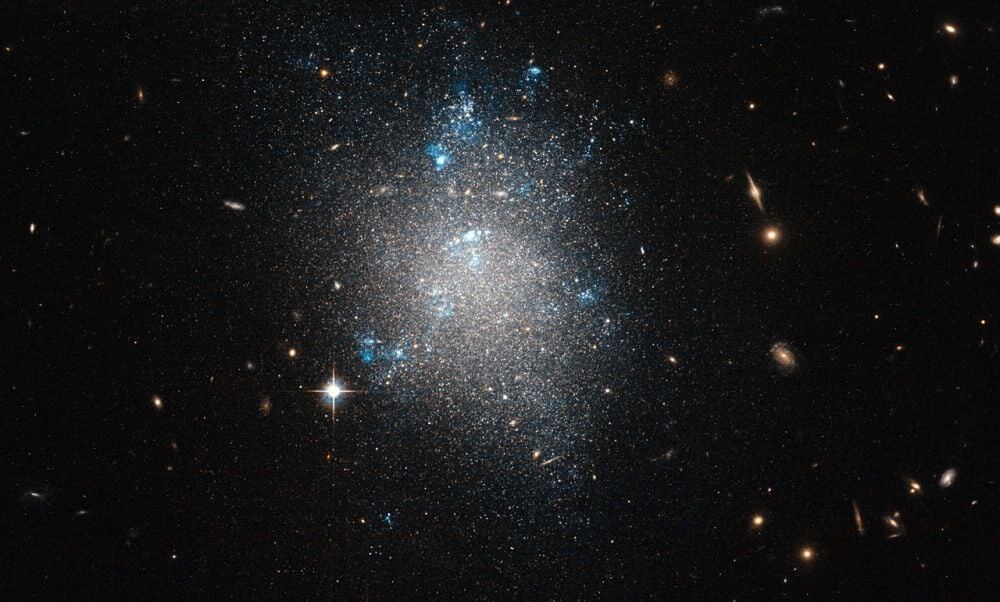 Карликовые галактики, подобные этой (NGC 5477), являются спутниками более крупных галактик, таких как Млечный Путь. Новое исследование изучило 36 далёких карликовых галактик, чтобы выяснить, есть ли у них собственные, меньшие по размеру, спутники. Цель — лучше понять, как формируются и эволюционируют галактики в парадигме лямбда-холодной тёмной материи.