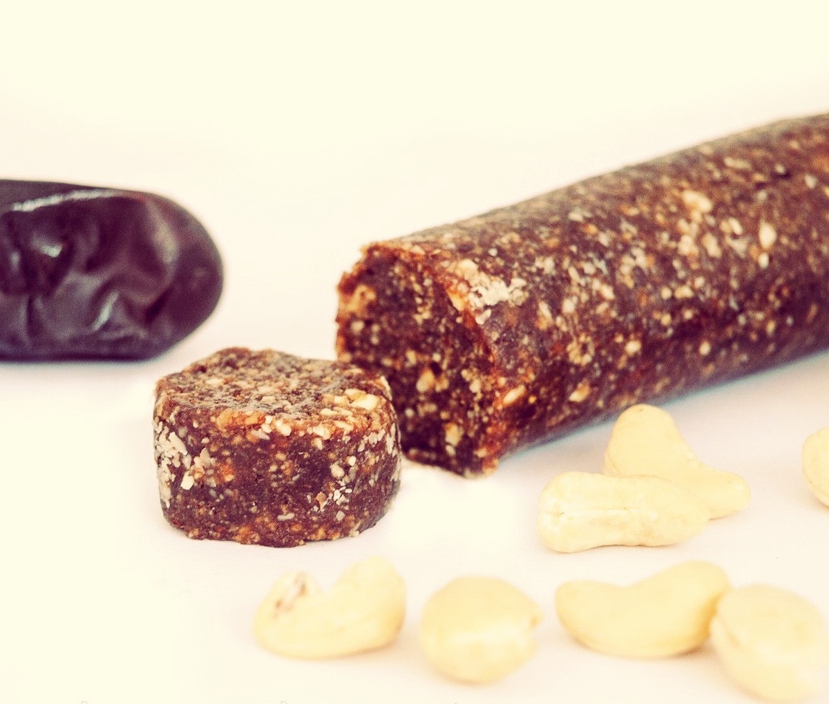    
Ингредиенты:

Сырое какао – несколько ложечек.
Льняная мука – 1/3 стакана.
Миндаль – 1/3 стакана.
Арахис – 1/3 стакана.
Грецкий орех – 1/3 стакана.
Кокос – 1/3 стакана.                                                                                                                                   Финики – 6-7 штук.
Масло какао – 5 ложек.

Приготовление:

Итак, финики мы освобождаем от косточек и делаем из них пюре.
Какао масло подогреваем на водяной бане.
Часть орешков мы измельчаем вместе с какао и мукой, а другую часть просто дробим на мелкие кусочки.
 Перемололи все в единую муку, добавляем к ней пюре из фиников, дробленые орешки и масло какао, тщательно перемешиваем вручную и придаем необходимую форму.

Ставим в холодильник или морозилку на застывание.