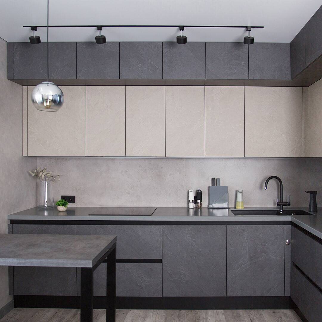 Популярное решение - секции в потолок с фальш-фасадами, придающими завершённый вид кухне. Реализованный проект мебельной фабрики "Мария".