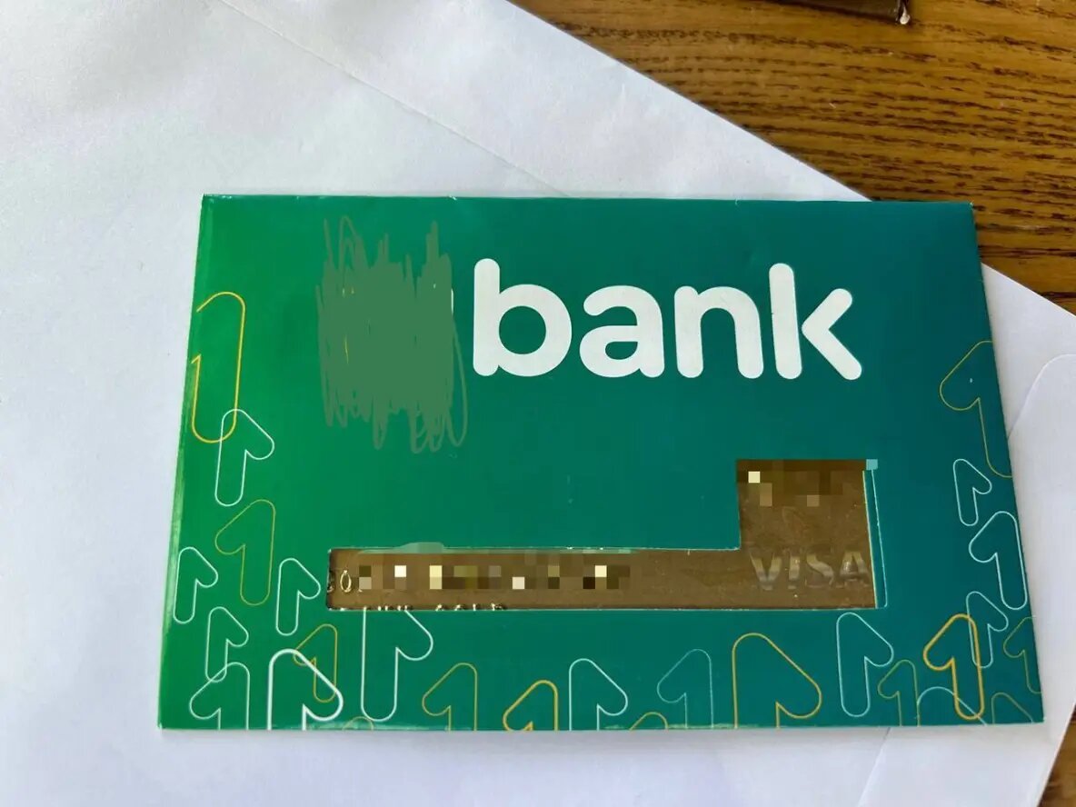 Карта приходит в запечатанном конверте и доставляется курьерской службой банка. 