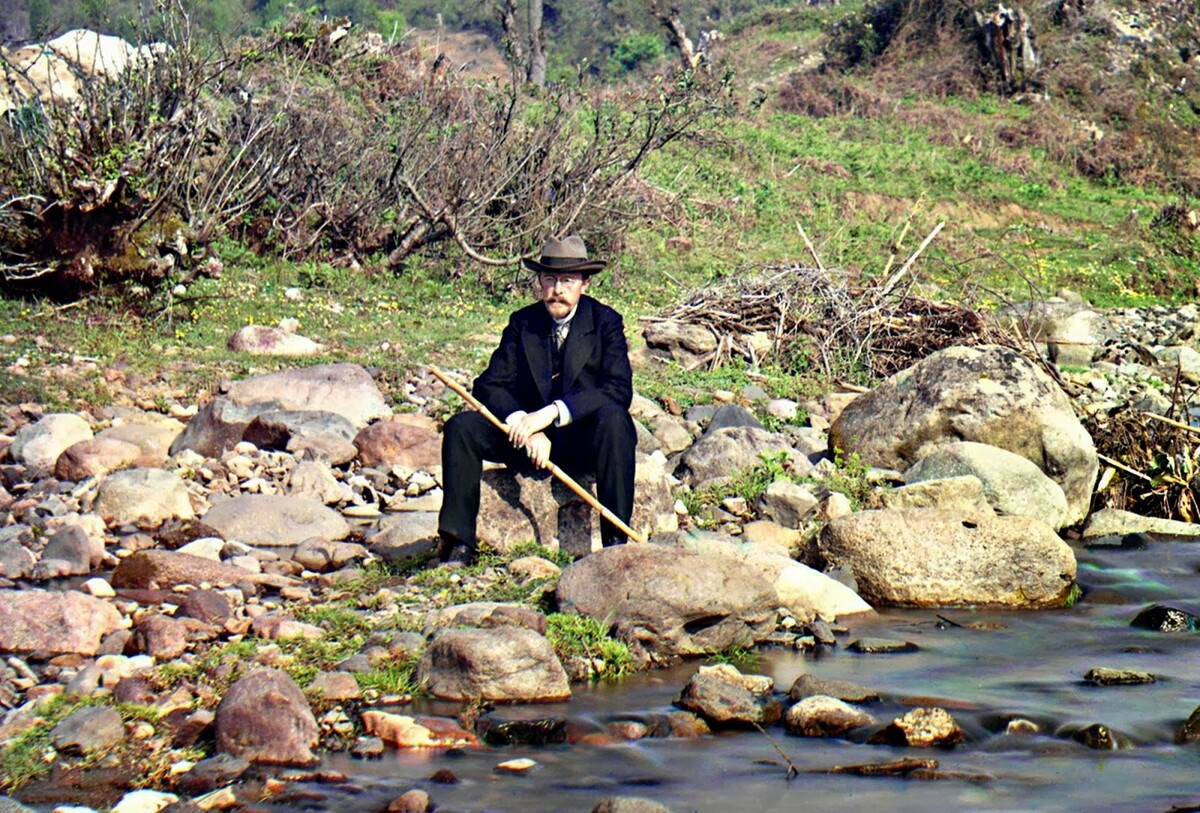Автопортрет на реке Каролицхали, около 1910 года. Прокудин-Горский в костюме и шляпе сидит на скале у реки Каролицхали, в Кавказских горах, недалеко от морского порта Батуми на восточном побережье Черного моря.