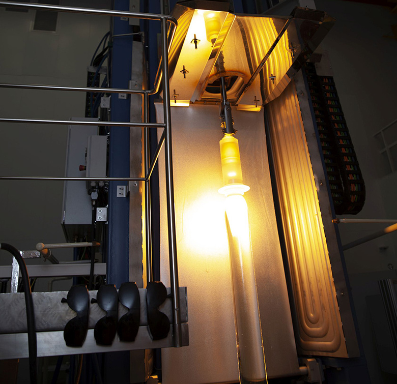 Заготовка из кварцевого стекла начинает превращаться в тончайшую нить