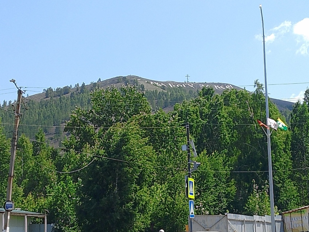 На врешине горы надпись - Слава Богу за всё.