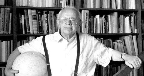 Станислав Лем на фоне своей библиотеки и с любимым глобусом под мышкой.