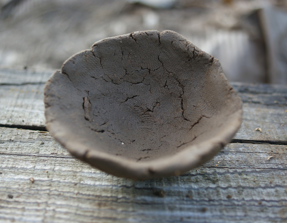 Просто наклонилась, взяла рукой немного земли и слепила. 