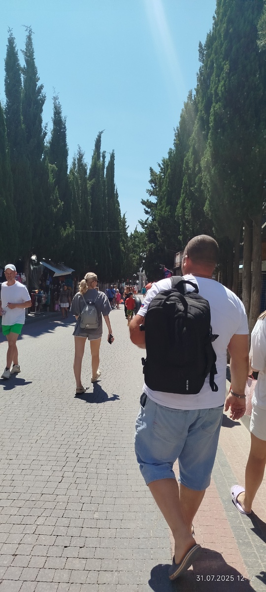 Кипарисовая аллея. Народу много, но в начале августа будет ещё больше. По обеим сторонам- различные точки продаж мороженого, косметики сувениров, хозтоваров, всякой всячины. 