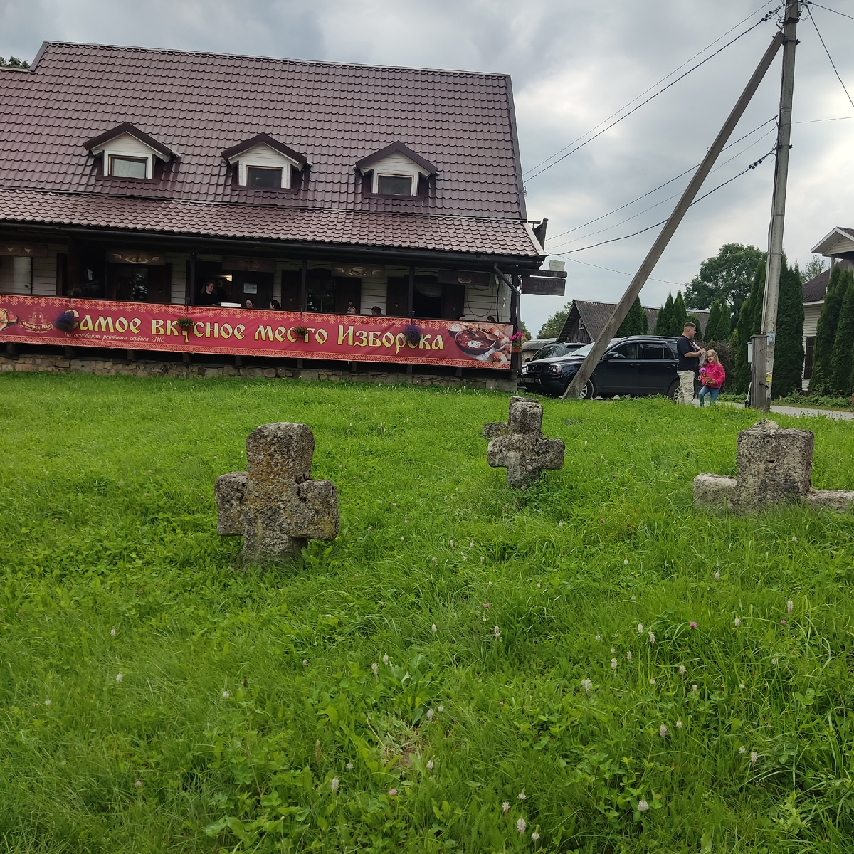 Такие каменные кресты встречают нас в центре Изборска. А рядом - кафе...