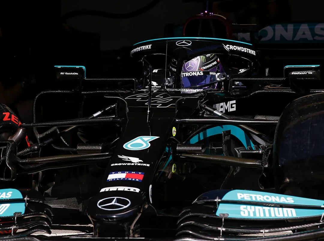 Пилот Формулы-1 в кабине Mercedes-AMG демонстрирует напряженную и сосредоточенную обстановку на скоростных гонках.