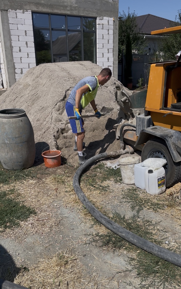 Подача песка и других материалов в машину, от которой шланг подает смесь в дом