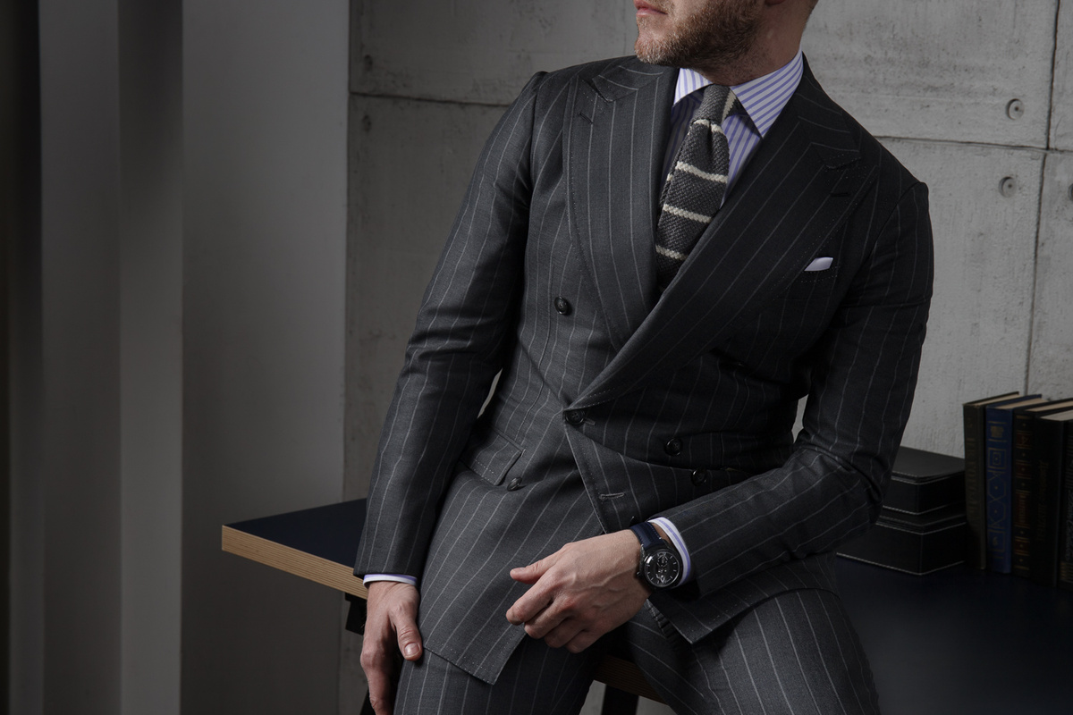 Двубортный костюм с широким лацканом темно-серого цвета в тонкую белую полоску.