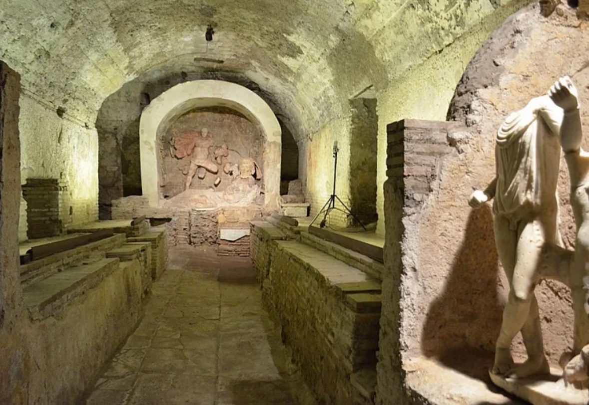 Реконструкция интерьера митреума с характерным алтарём и скамьями