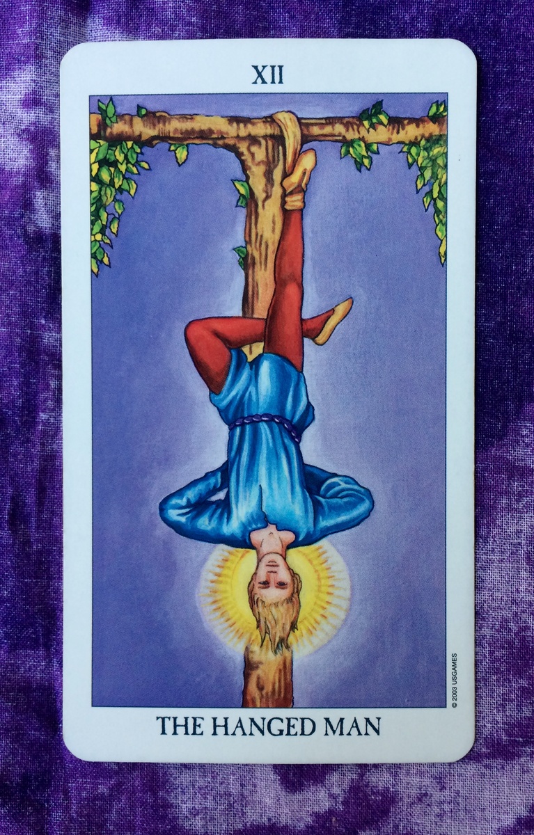 Аркан "Повешенный" в Таро – карта не из простых. В ней несколько смыслов. Во-первых, это символ посвящения, отсюда и сияние вокруг головы персонажа.


Во-вторых, это жертва, но добровольная. Именно поэтому герой висит вниз головой, но выглядит вполне расслабленно.


Тут вспоминается миф об Одине, который приковал себя к Мировому Древу, принеся себя в жертву самому себе, чтобы познать руны.


Все это – метафора инициации и самопожертвования ради мудрости и интуитивного знания.


Мировое Древо – это символ Самости, а жертва – это умерщвление Эго, разрушение ложного "Я", иллюзий о себе, чтобы обрести истинный центр, включающий сознательное и бессознательное.


Обретение целостности и осознание скрытых сторон себя – это как просветление, обретение мудрости.


Вот что такое "Повешенный" в Таро. Иногда эту карту называют "Жертва".


Если рассматривать "Повешенного" как метафору, то подвешенное состояние – это переходный период, когда старые ориентиры потеряны. Человек чувствует себя в подвешенном состоянии, в неопределенности. И это сложно для большинства.


Это состояние – предвестник больших перемен. Прошлое уже позади, а будущее еще не наступило, отсюда и ощущение "подвешенности". Ориентиры теряются в кризисы, когда мы переоцениваем ценности и ищем новые смыслы. Но в итоге мы находим новые ориентиры и растем.


Возрастные кризисы – это моменты инициации. Инициации – это развилки, когда формируется что-то важное для перехода на новый уровень.


Переходное состояние – признак трансформации. И это преддверие перемен, хотя неопределенность может пугать.


Неопределенность тревожит, потому что безопасность – это предсказуемость. Но безопасность ограничивает свободу, поэтому путь к свободе – это выход за рамки привычного и безопасного.