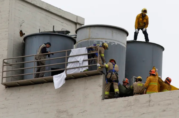 Бригада спасателей извлекает тело. Тело 21-летней Элизы Лэм из Ванкувера, Канада, было обнаружено в резервуаре для воды на крыше отеля «Cecil» ремонтником, который пытался выяснить причину низкого давления воды.