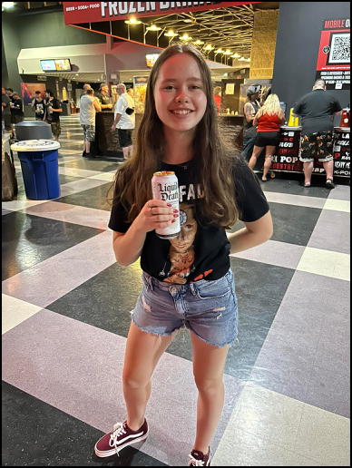 Моя дочь с дорогущей бутылкой Liquid Death на концерте.