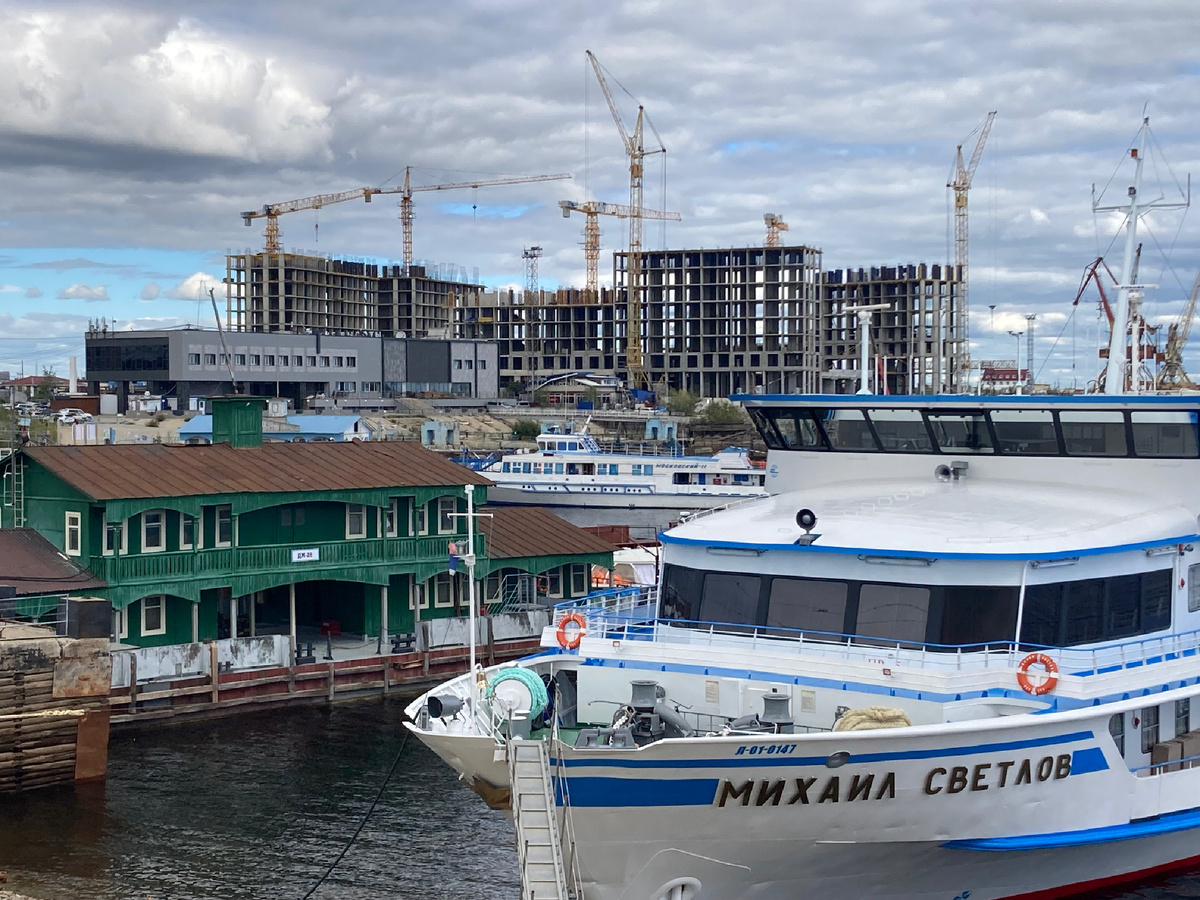 Деревянный домик вокзала неизвестного века постройки и бетонные блоки новостроек на фоне теплохода по имени «Михаил Светлов»