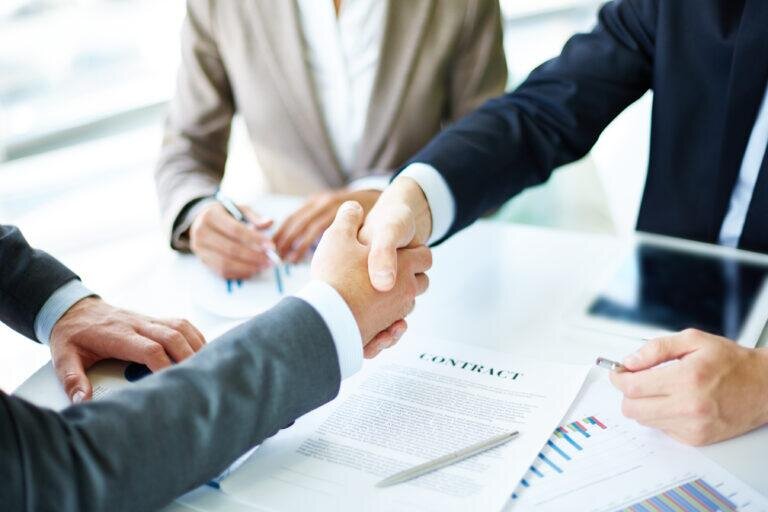    Image of business partners handshaking over business objects on workplace Артем Силантьев