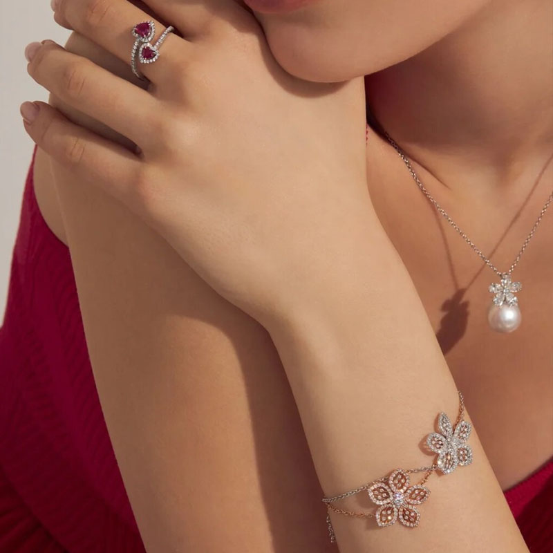 Браслеты Miss Russia из белого и розового золота с бриллиантами, кулон Flower из белого золота с бриллиантами и жемчугом и кольцо Color из белого золота с бриллиантами и рубинами, все Mercury