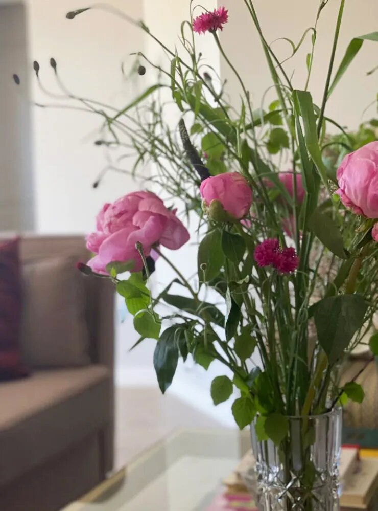 Более массивные и плотные бутоны пионов составляют основу букета, а легкие васильки и травы «парят» над ними. Листва обрамляет нижний ярус