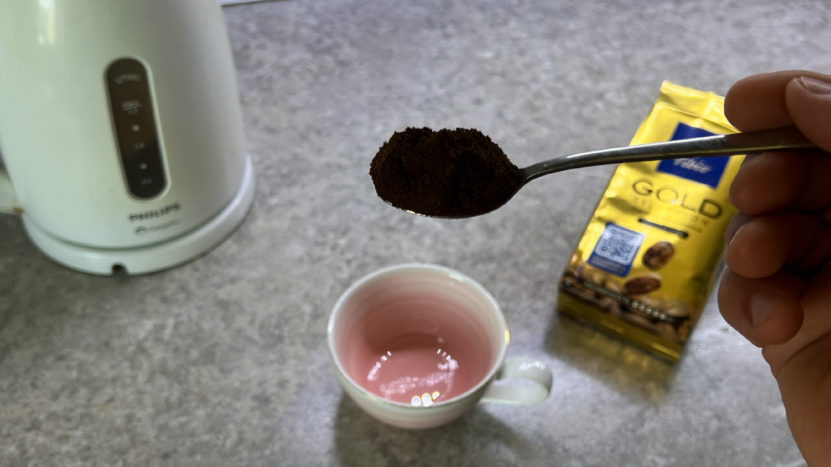 Фото чашки кофе с ложкой и пачкой Tibio