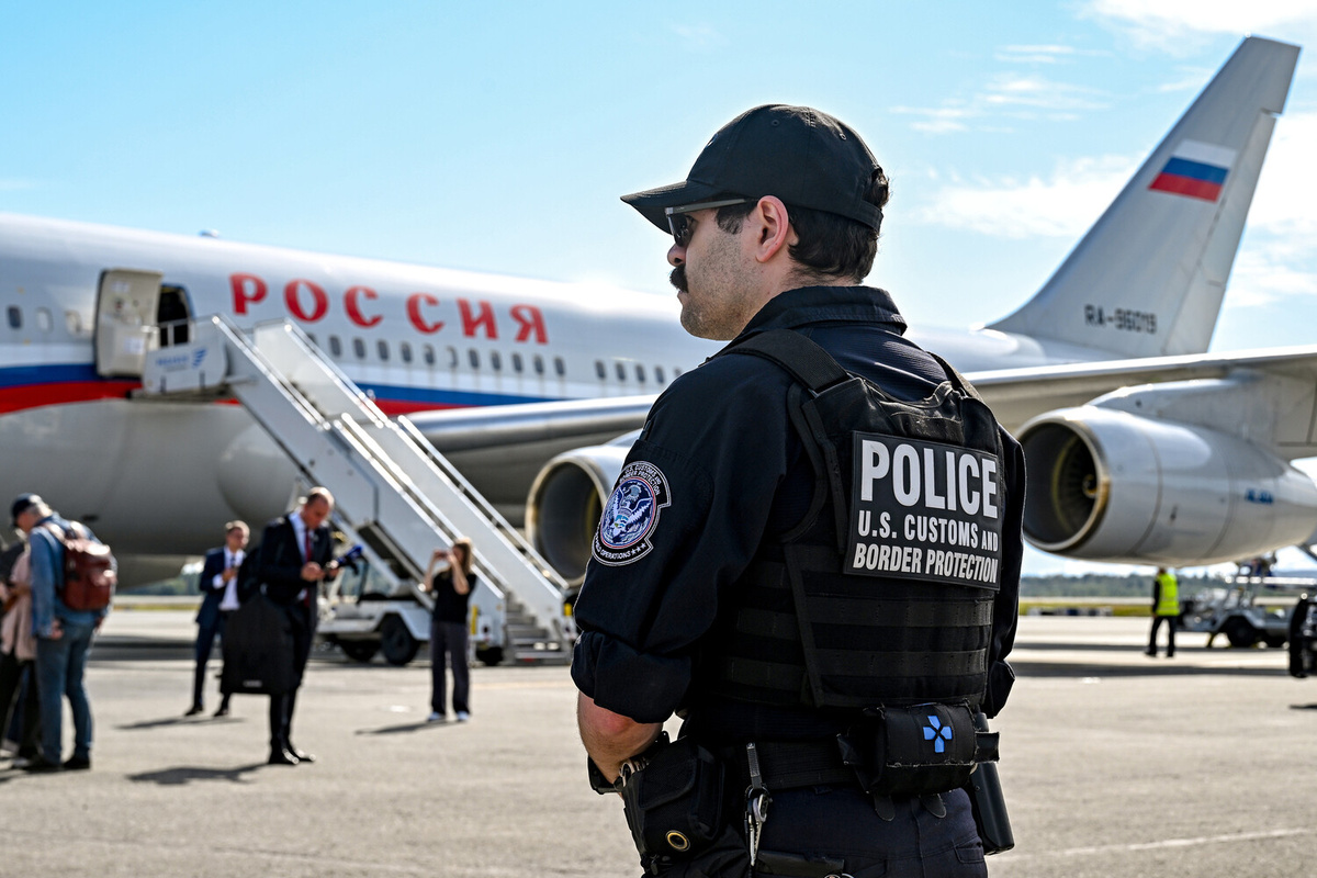 Сотрудник полиции на фоне самолета Ил-96-300 специального летного отряда "Россия", вылетевшего из московского аэропорта "Внуково", в Международном аэропорту Анкоридж имени Теда Стивенса, 14 августа 2025 года ©Сергей Бобылев/РИА Новости  📷
