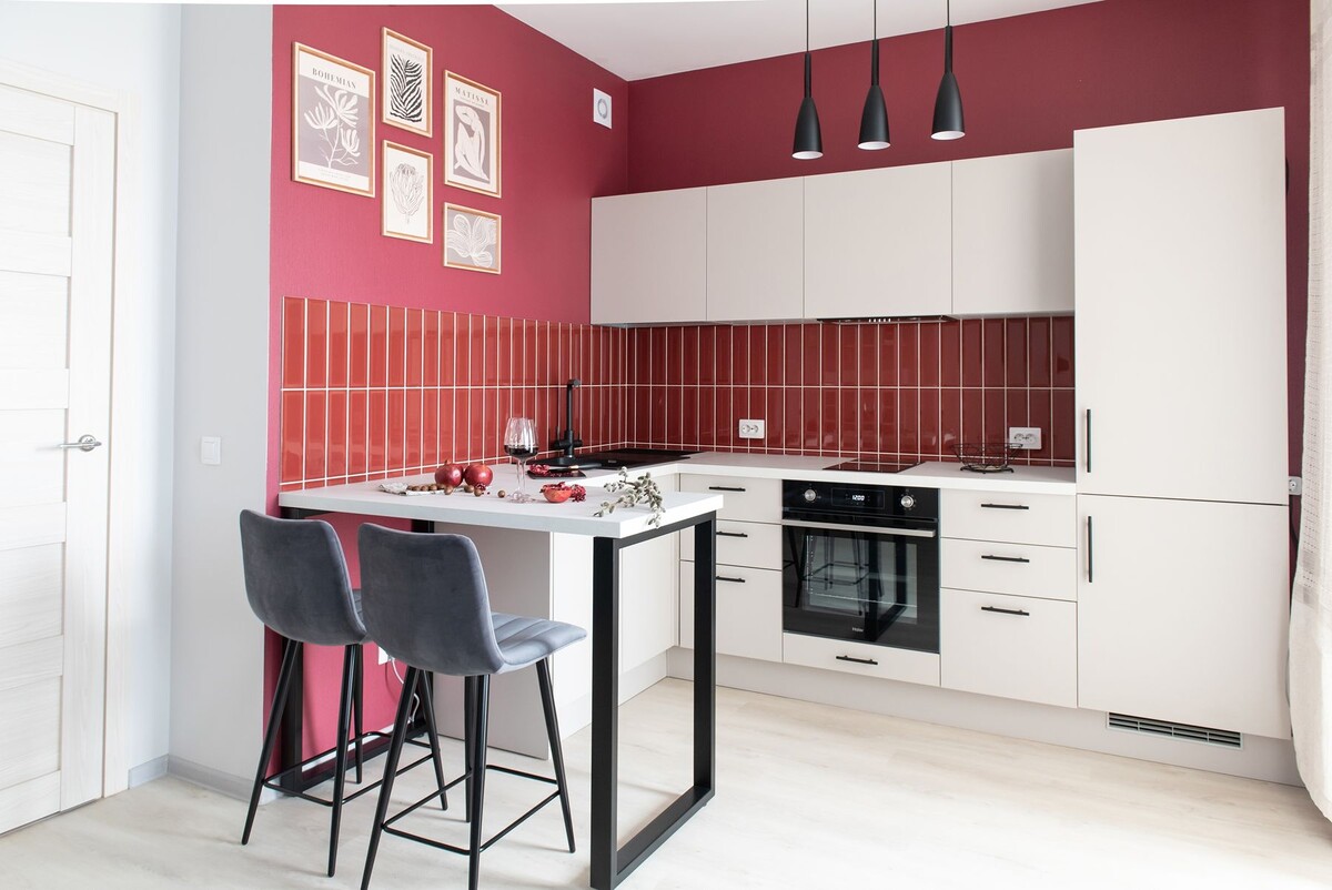 Красные акценты на стенах и фартуке не надоедят при длительной эксплуатации
