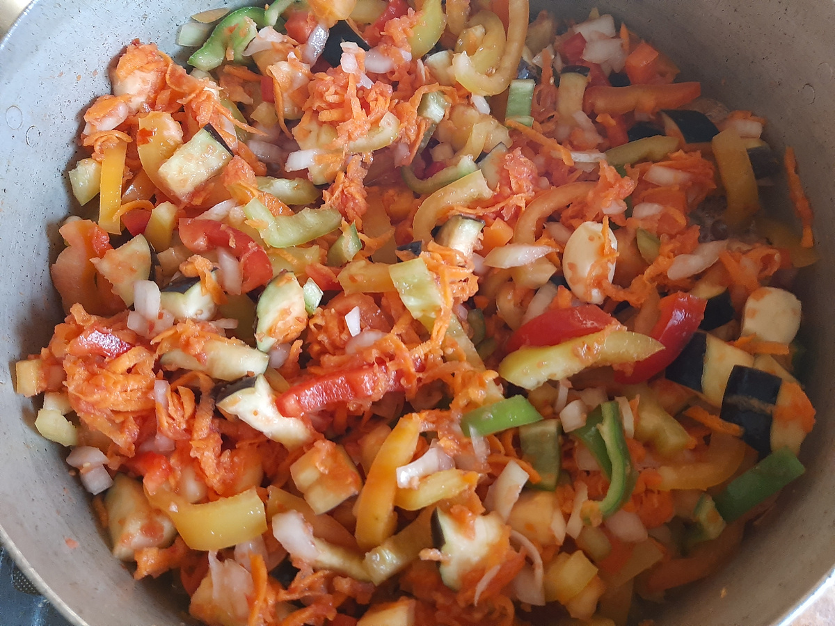 Все овощи объединены, перемешаны и отправляются на огонь. После закипания, огонь убавить до минимума. Вначале можно закрыть крышкой, а потом варить без неё, чтобы выпарить лишнюю жидкость.