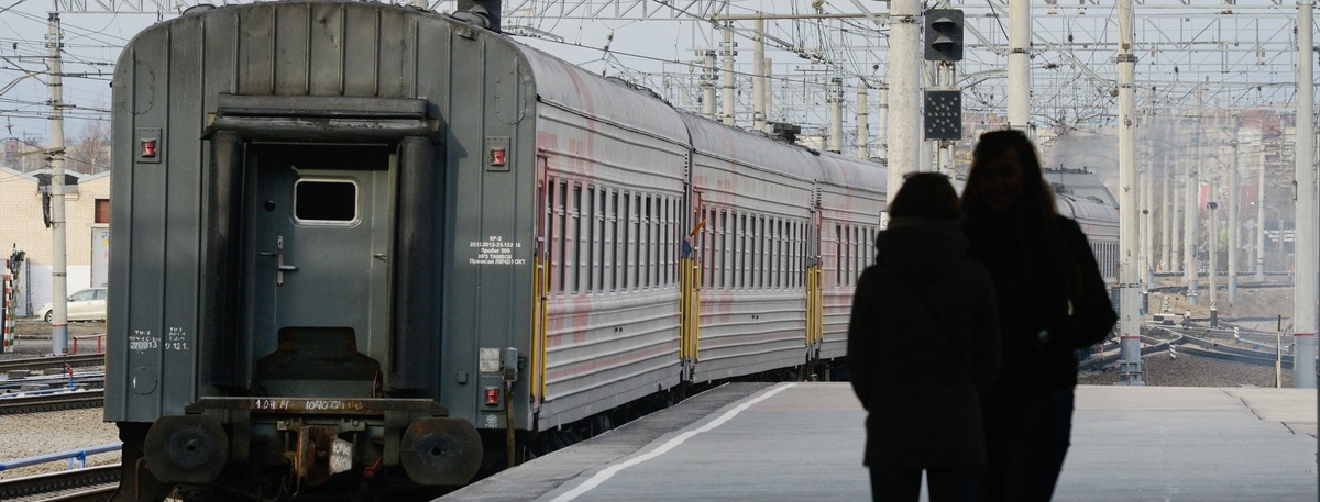    Две девушки наблюдают, как пассажирский поезд отправляется с Ладожского вокзала в Петербурге. Автор фото: Сергей Ермохин / "Деловой Петербург"