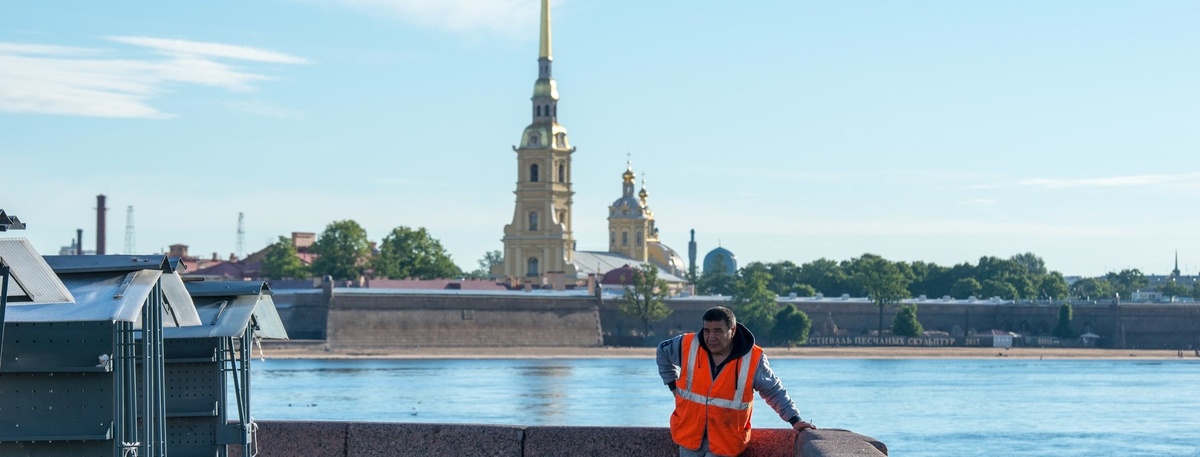   Трудовой мигрант отдыхает на набережной напротив Петропавловской крепости в Петербурге. Автор фото: Михаил Тихонов / "Деловой Петербург"