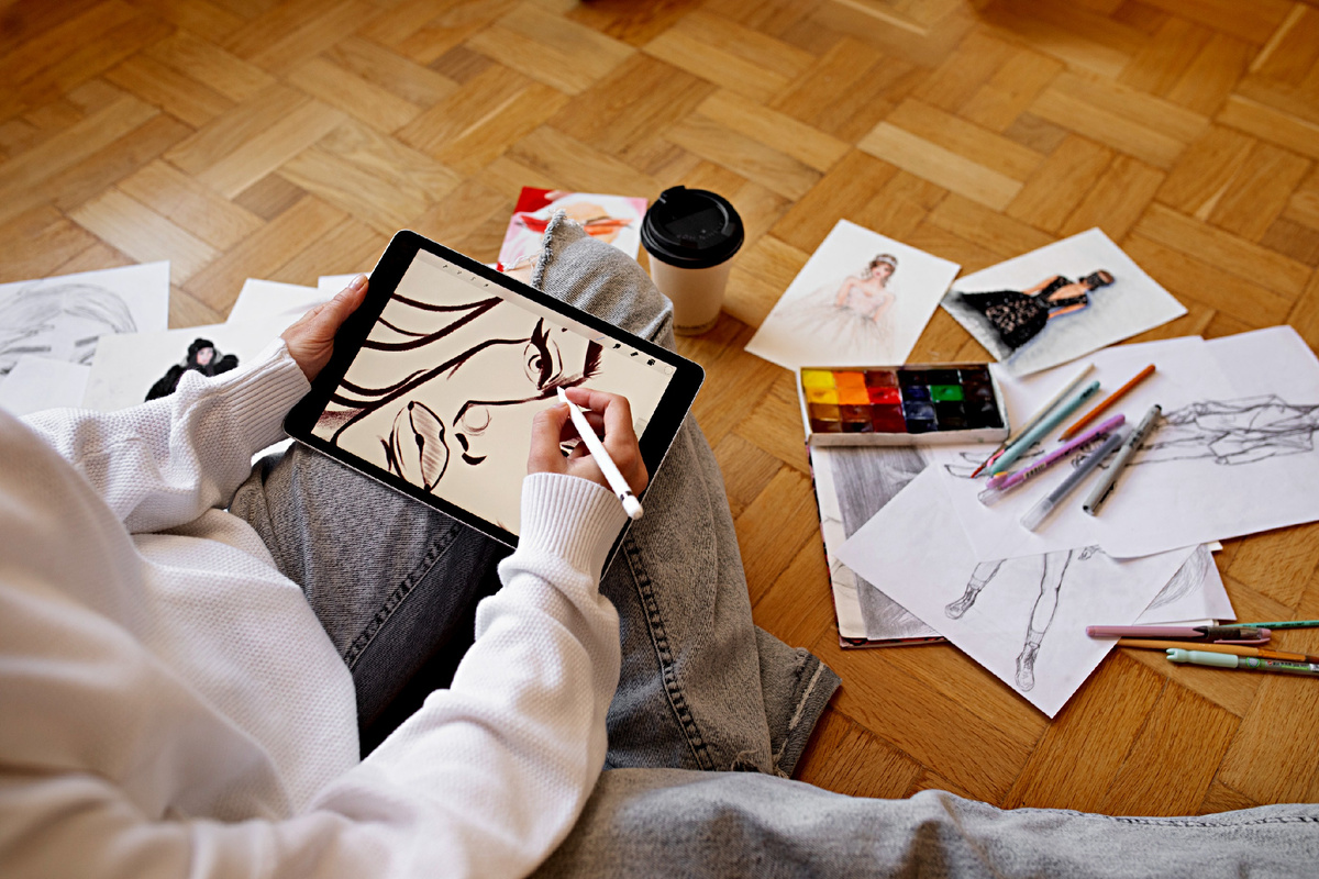 Девочка-подросток рисует иллюстрацию на планшете