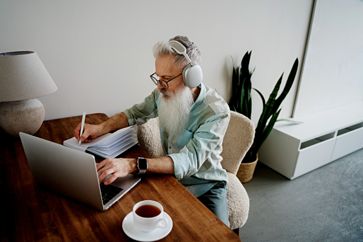 Пожилой мужчина за ноутбуком дома