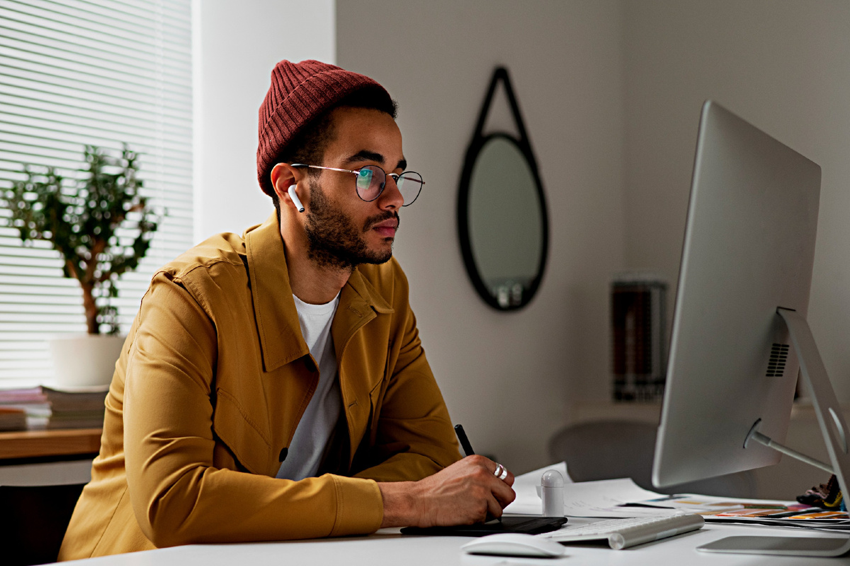 Мужчина работает за ноутбуком, создавая инфографику