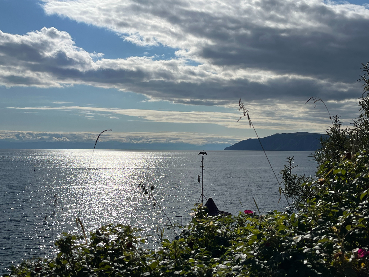 Вид на Байкал из Листвянки. Баклан на мачте раскрыл крылья и изобразил крест. Но это живая птица. Просто такой удачный и забавный момент. 