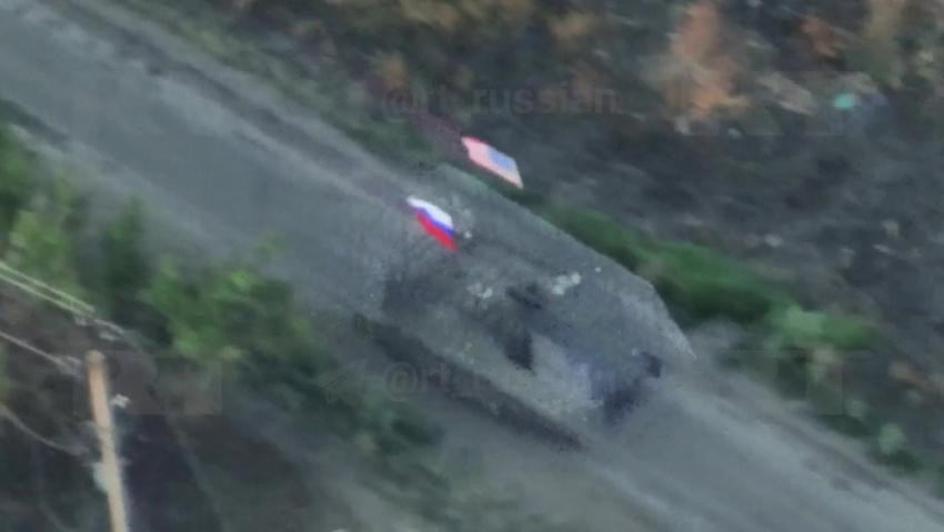    Кадр из видео с бойцами РФ на трофейном БТР с флагами США и РФ в Малой Токмачке