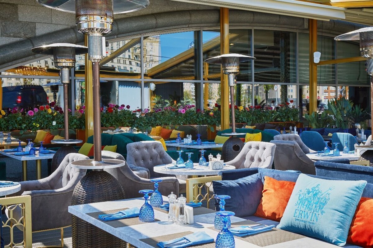 Летняя терраса ресторана "Erwin" - атмосферное пространство с уличной мебелью.