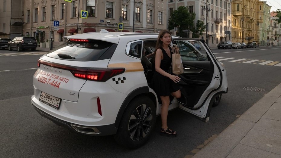    Девушка высаживается (выходит) из такси. Автор фото: Тихонов Михаил