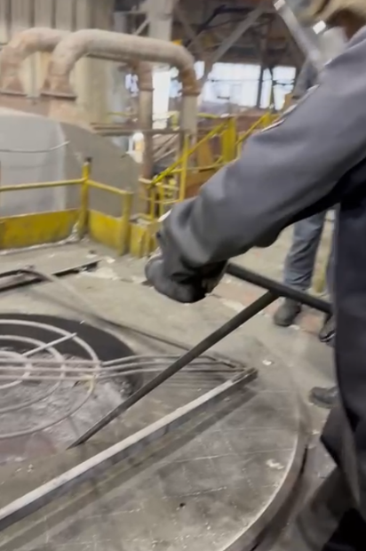 Ручная очистка печи от шлака скребком.