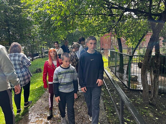 Дети идут по дорожке зоопарка