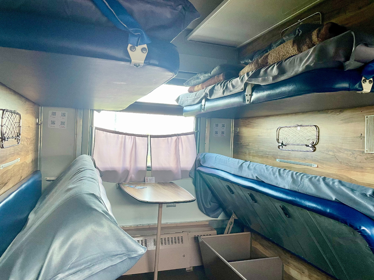 Наше купе — всё по-настоящему: полки, столик, чай и разговоры.