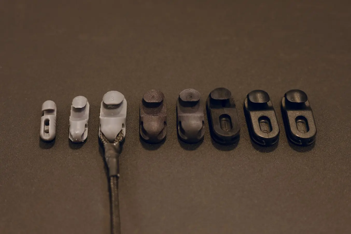 Слева: прототипы, напечатанные на SLA-принтере из Tough 2000 Resin. В центре: детали, напечатанные на SLS-принтере из нейлона 12 и изготовленные методом ЧПУ и литья из PA66. Справа: готовые литые детали из PA66.