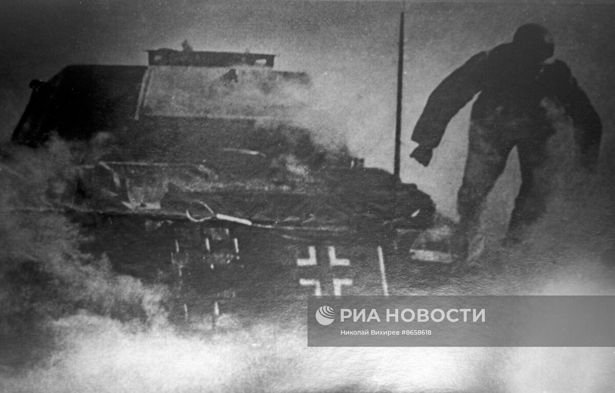 Немецкий солдат эвакуируется из горящего танка.