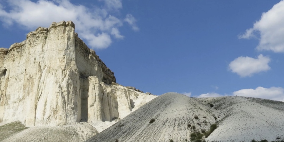 Белая скала Ак-Кая в закатных лучах и следы древней стоянки