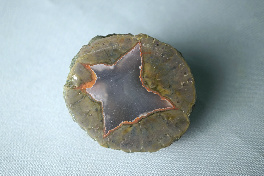 Миндалина выполненная породой с голубовато-серым халцедоном.