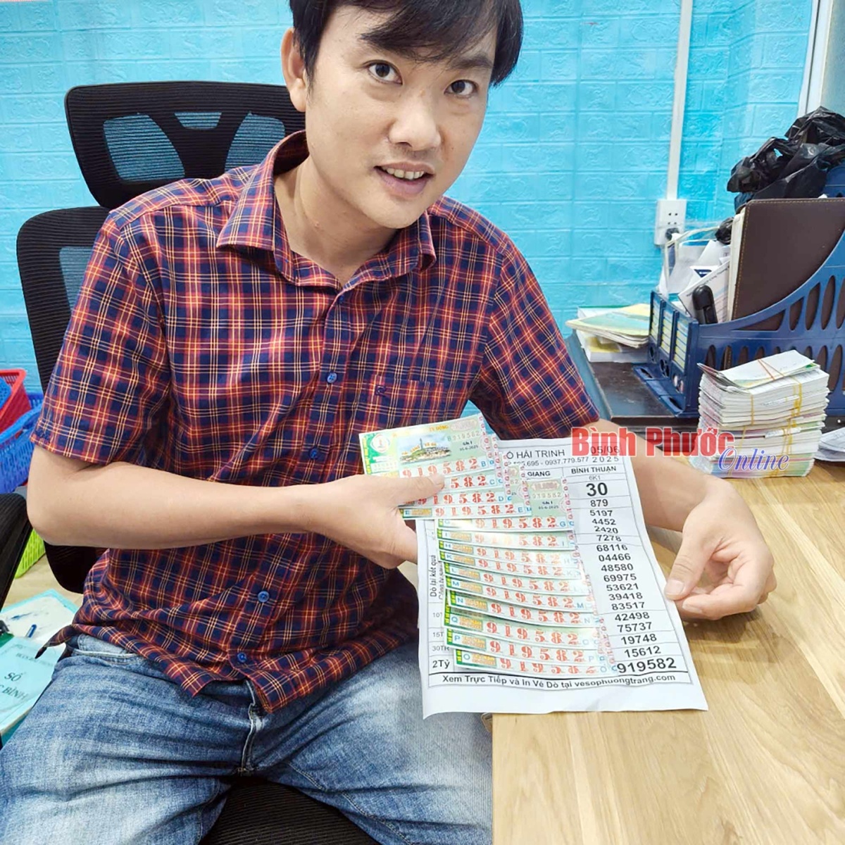 Это не обладатель выигрыша, а представитель филиала лотерейной компании господин Хай Чинь. Он рассказывает об обмене 14 лотерейных билетов со специальными призами на денежный выигрыш.