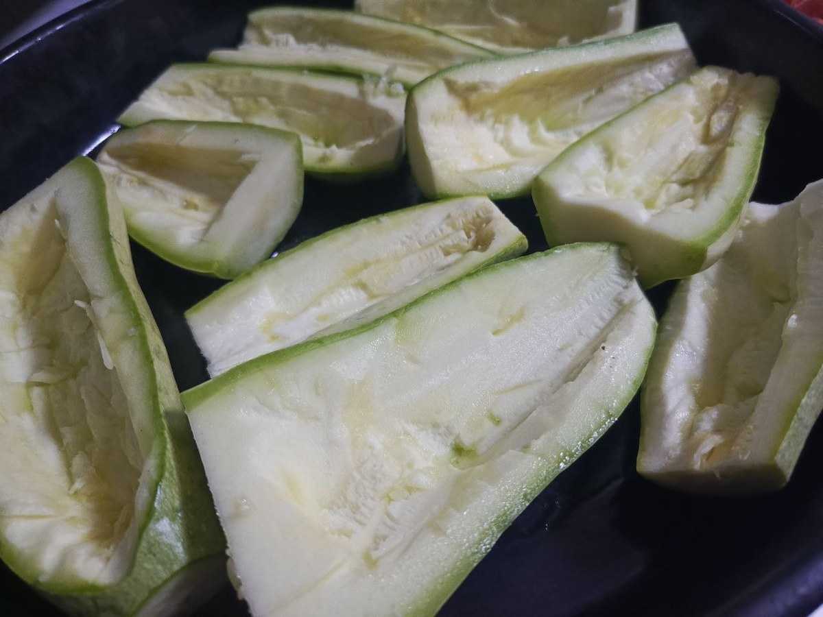 Подготовьте кабачки. Сначала вымойте их, а затем отделите плодоножки, разрежьте кабачки пополам, после чего сделайте в них выемки, как показано на фото. В них будет выкладываться начинка.